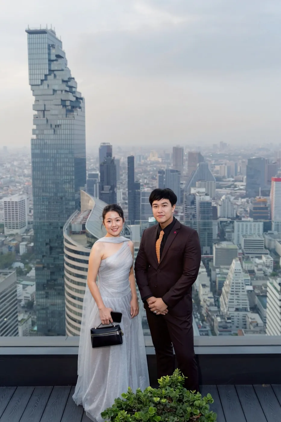 Two A.D. advisors at a rooftop evening event above Bangkok