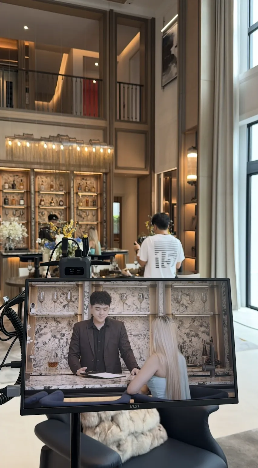 A professional crew filming A.D. advisors inside a show house, seen on the monitor